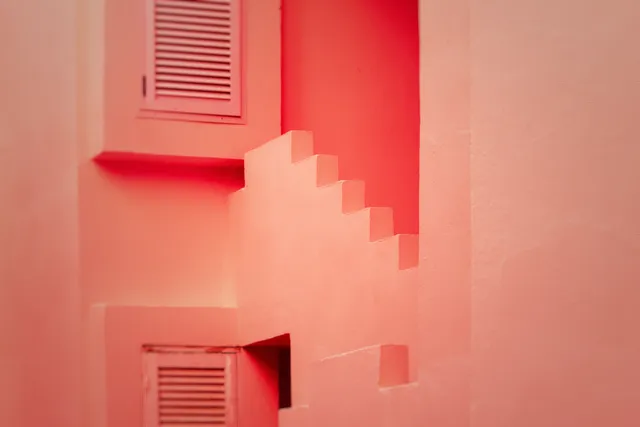 Pink stairways at La Muralla Roja with the Holga 120N treatment, softer outer edges, darker corners, and fine grain.